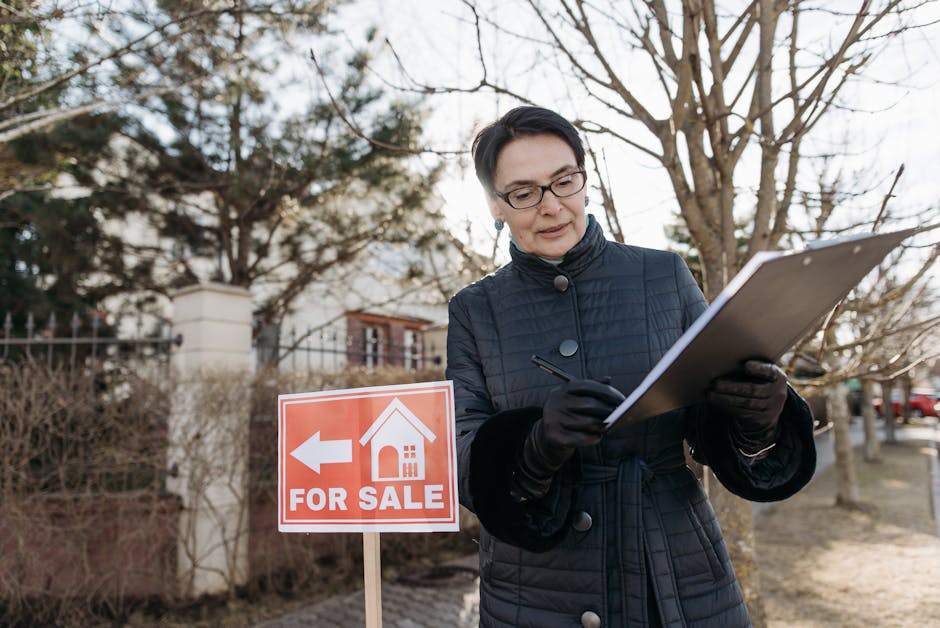 A real estate agent reviews a clipboard next to a  For Sale  sign outside a property on a clear day.